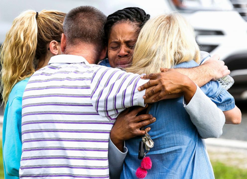 PHOTO: Nikki Brown, center, hugs others in front of Forest High School on April 20, 2018 in Ocala, Fla. 
